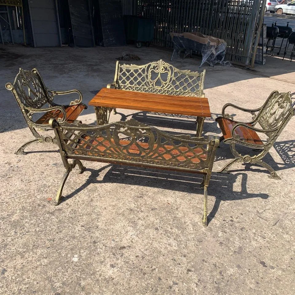 Juego de sillón diseño Imperial: dos bancos de tres cuerpos, dos sillones y una mesa central, en aluminio fundido tono bronce con listones de lapacho
