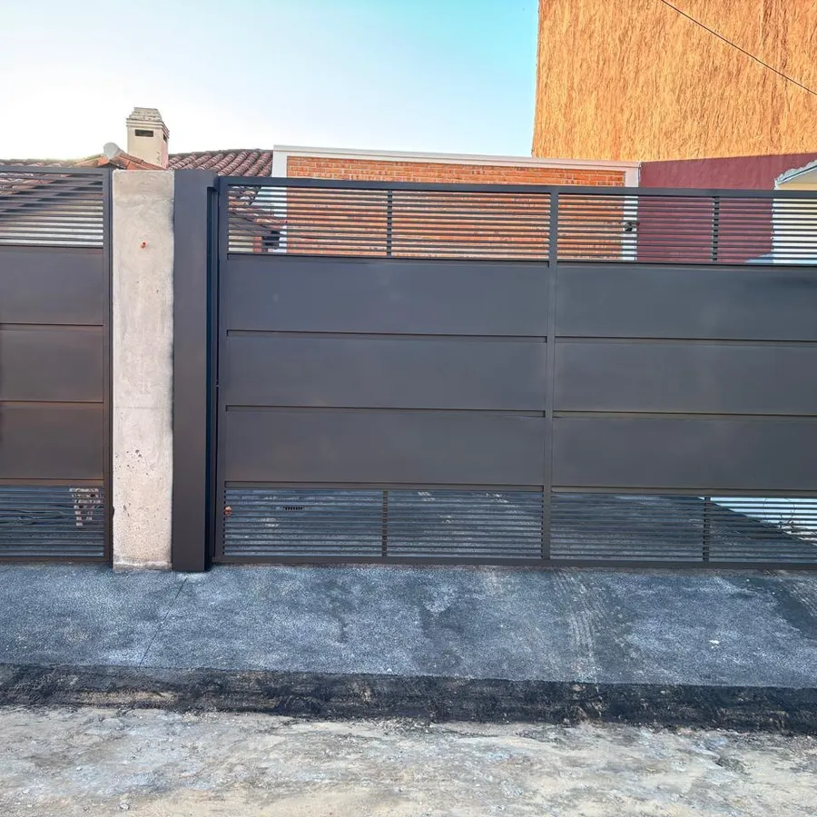 Portón corredizo de hierro negro con listones horizontales, ya colocado